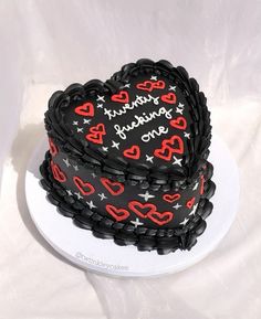 a heart shaped cake with red and black frosting