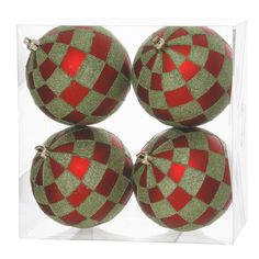 four red and green christmas ornaments in a clear box with reflection on the bottom surface