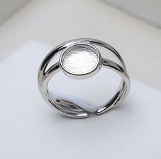 a silver ring sitting on top of a white surface