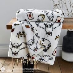 the harry potter towel is on top of a wooden bench in front of a vase