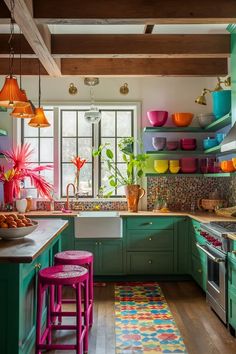 a kitchen with green cabinets, pink stools and lots of colorful dishes on the shelves