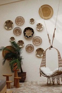 a living room filled with lots of wicker furniture and hanging baskets on the wall