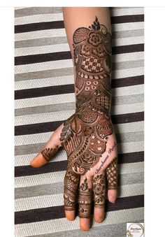 a woman's hand with henna tattoos on it