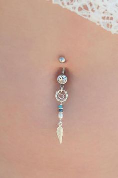 the back of a woman's stomach with a belly ring and dangling beads on it