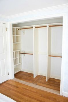 an empty closet with white walls and wooden floors