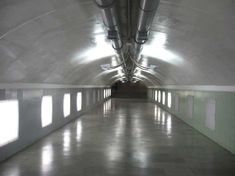 an empty tunnel with light coming in from the ceiling