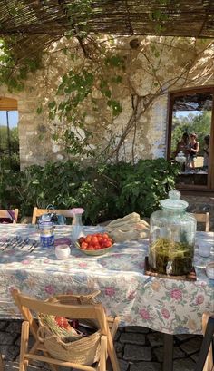 an outdoor table with food and drinks on it