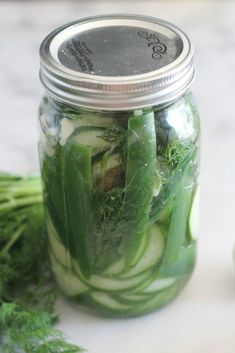 a jar filled with cucumbers and green onions