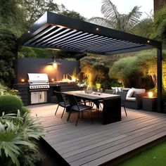 an outdoor kitchen and dining area is lit up at night