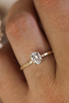 a woman's hand with a diamond ring on top of her finger and an engagement band