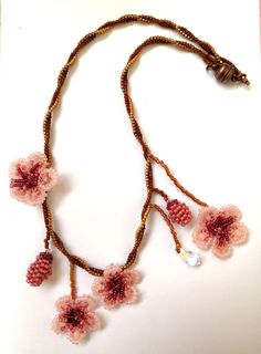 Thene of a kind asymmetrical beaded cherry blossom necklace, 100% designed and hand-crafted by me! This 40 cm unique, artisan jewelry is meant to look exactly like the magnificent spring cherry blossom branches so you can wear one on your neck and look like an ethereal nymph! It is entirely made with premium quality miyuki glass beads that they are known to made exclusively in Japan and are considered one of the most refined, luxurious tiny beads in the world! You will not wear a simple necklace. This is a piece of art made with thought, care, love, and the highest quality materials. In the personalization section, you can type the length you prefer as well as your own adjustments regarding the style of the necklace. Handmade Pink Choker As Gift, Handmade Pink Choker As A Gift, Pink Beaded Necklace With Flower Pendant, Handmade Delicate Beaded Necklaces With Round Beads, Handmade Delicate Beaded Necklace With Round Beads, Delicate Handmade Beaded Necklaces With Round Beads, Pink Beaded Flower Pendant Jewelry, Pink Beaded Flower Pendant Necklace, Handmade Delicate Flower Beaded Necklaces