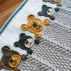 there are crocheted teddy bears on the blanket that is laying on the floor