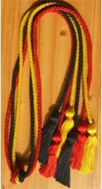 three tassels with yellow, red and black colors on wooden floor next to each other