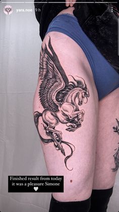 a woman's thigh with an eagle and horse tattoo on it