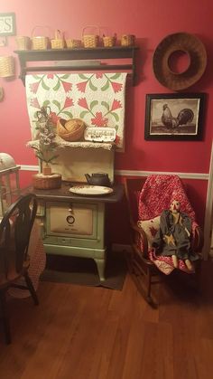 an old fashioned stove sitting in the corner of a room with red walls and wooden floors