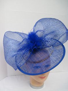 "* Bring in a little excitement to your fashion this season with this bright blue Sinamay hat designed with one gigantic netted bow. Accented with matching Ostrich feathers this is an eye catcher. * The hat is oval with a 2-1/2\" brim and with the clip on the inside can be positioned as desired. The pictures show just two positions as my model has no hair! * This particular design is off the center of the head and can be worn on either the right or left side of the head. * It is light weight, we Spring Party Hat With Ostrich Feathers, Blue Summer Fascinator Hat, Adjustable Blue Hats For Church, Blue Feather Trim Fascinator For Kentucky Derby, Adjustable Blue Hat For Church, Blue Adjustable Hat For Church, Blue Hats With Feather Trim For Weddings, Blue Hat With Feather Trim For Weddings, Adjustable Blue Fascinator With Feather Trim