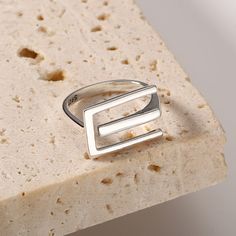 Este elegante y minimalista anillo geométrico de la letra E está hecho de metal de alta calidad y es el accesorio perfecto para agregar un toque moderno a su guardarropa.  Su diseño minimalista y su forma geométrica lo convierten en una adición atemporal a cualquier colección.
 Detalles del producto

Material: Plata 925
Color: chapado en oro blanco.
Tamaño: US Size #8 Ajustable
Peso: alrededor de 3,2 g
SKU: AR23101825

 Palabras clave del producto:  Anillos de banda distorsionados , Anillos de A Plain Ring, Plain Rings, Rings Unique, Adjustable Weights, Rings Vintage, Letter E, Vintage Band, Geometric Lines, Design Minimalista