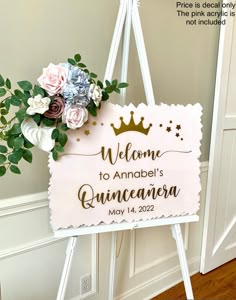 a welcome sign with flowers on it in front of a door and a wooden floor