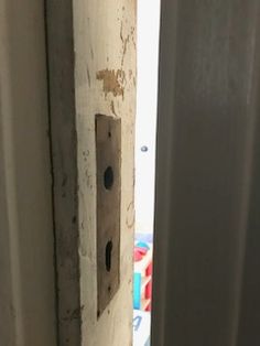 an open door with a hole in the middle and a light switch on it's side