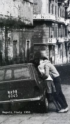 two people leaning on the back of a car