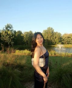 a woman is standing in front of a pond