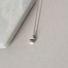 A dainty minimalist accessory that's perfect for everyday wear! This necklace features a tiny sterling silver pebble charm paired with sterling silver cable chain. The small disc is 5mm wide and about 2mm thick and it has a sleek bright polish that gives the necklace a modern feel. The simple design makes this a versatile accessory and it looks chic alone or layered with others. The necklace is fastened with a sterling silver spring ring clasp and you can choose your desired length from the drop Simple Round Pendant Charm Necklace For Everyday, Minimalist Sterling Silver Charm Necklaces For Everyday, Minimalist Tiny Charm Necklaces For Everyday, Simple Sterling Silver Necklaces, Dainty Tiny Charm Necklace With Round Pendant, Minimalist Everyday Charm Necklace With Simple Design, Everyday Minimalist Charm Necklace With Simple Design, Adjustable Tiny Charm Necklaces For Everyday, Everyday Minimalist Sterling Silver Charm Necklace