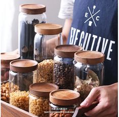 a person standing in front of jars filled with nuts