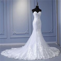 a white wedding dress on a mannequin in front of a blue wall and floor