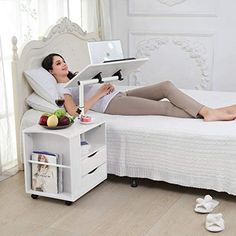 a woman is laying on her bed while using a laptop computer and holding a tablet