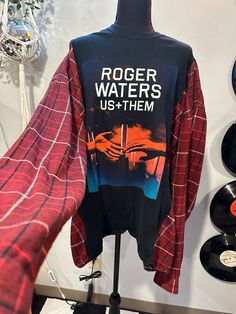 a t - shirt that says roger waters us and them on it next to records