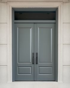 two gray doors are open in front of a building