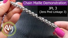 the chain is being held by two hands with pink nail polishes on their nails