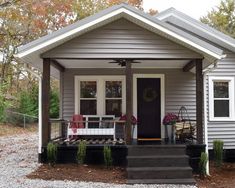 a small gray house with porch and front door