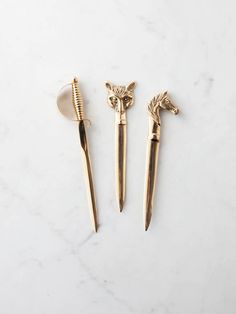 three gold toothbrushes sitting next to each other on a white counter with a marble surface