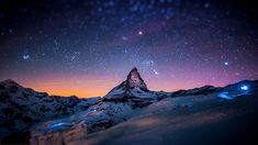 the night sky is filled with stars and bright lights as it shines brightly over snow covered mountains