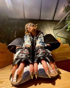 a woman sitting on top of a wooden table wearing roller skates and holding onto her legs