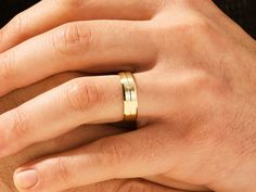 a man's hand with a gold wedding ring on his left and right hand