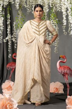 Off white saree drape gown with sequins and beads embellished bodice and stripe pattern detailing.
Components: 1
Pattern: Embellished
Type Of Work: Sequins
Neckline: V Neck
Sleeve Type: Puff Sleeves
Fabric: Handloom Silk Stripes and Silk Blend With Zari 
Color: Off White
Other Details: 
Attached inner lining
Length (in inches: 57
Floral embellished cuffs
Occasion: Sangeet - Aza Fashions Saree Gowns, Off White Saree, Drape Gown, Saree Drape, Gown For Women, Saree Gown, White Saree, Gowns Online, Stripe Silk