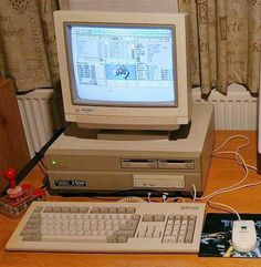 an old computer sitting on top of a wooden desk next to a keyboard and mouse