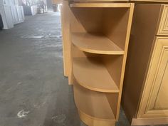 a corner shelf in the middle of a kitchen with cabinets and cupboards behind it