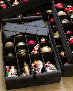 two black boxes filled with ornaments on top of a wooden floor