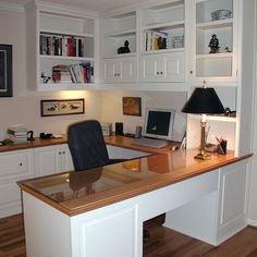 a home office with white cabinets and wooden floors