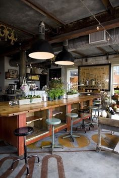 an industrial style kitchen with wooden counter tops and stools