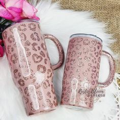 two pink coffee mugs sitting next to each other on a white furnishing