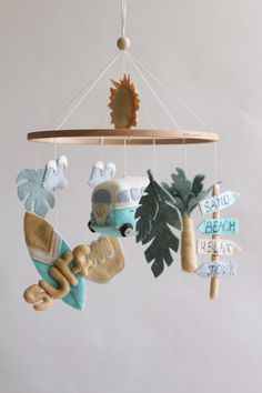 a mobile that has various items hanging from it's hooks and is decorated with palm trees