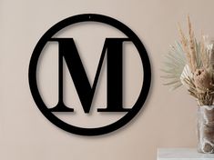 there is a vase with flowers in it next to a sign that says m on the wall