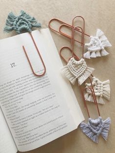 an open book with paper clips attached to it next to some tassels on the pages