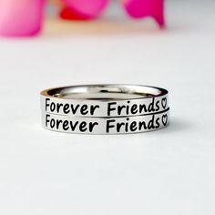 "This listing is for 2 stainless steel band rings, engraved with \"Forever Friends\" + a heart symbol on the outside. It makes a very lovely gift for your best friends, best sisters. Materials & Features: This ring is made of high quality hand polished solid stainless steel, which is hypoallergenic (good for metal-sensitive skin). Stainless steel will not tarnish, its luster and durability will make it last for many years. The black text on the ring will not fade out over time. Sizes: This ring Nickel-free Stainless Steel Promise Ring, Silver Stainless Steel Stackable Rings, Hypoallergenic Stainless Steel Promise Ring, Personalized Sterling Silver Rings For Friendship, Stainless Steel Rings For Valentine's Day Anniversary, Adjustable Stainless Steel Engraved Ring, Valentine's Day Promise Ring In Stainless Steel, Stainless Steel Promise Rings For Valentine's Day, Engraved Stainless Steel Promise Ring