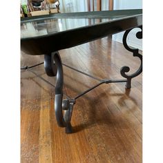 a black table with metal legs on a wooden floor