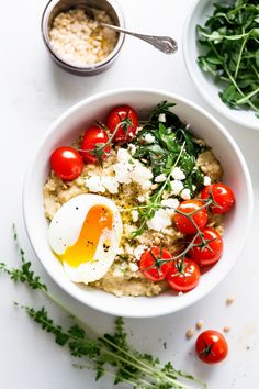 a bowl filled with oatmeal, tomatoes and an egg on top of it